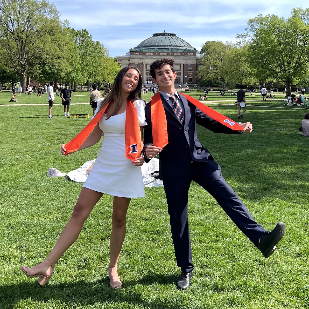 Davis and Lara posing in graduation stoles on the University of Illinois Quad.