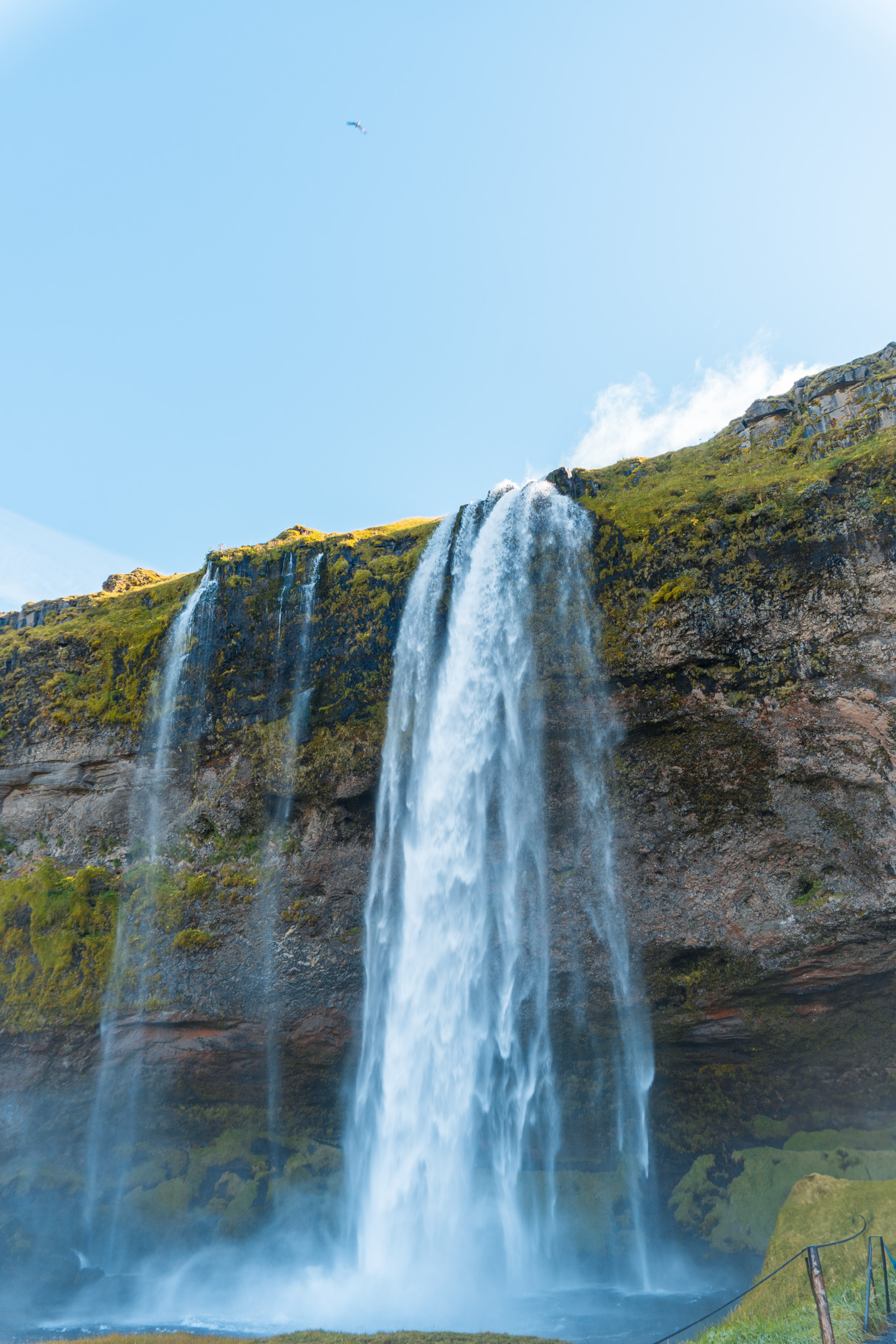 Tall waterfall at Seljalandsfoss in Iceland under a clear sky.